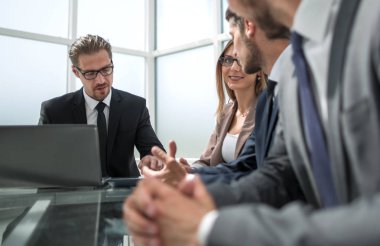 Neşeli ofis çalışanları yaptıkları proje tartışıyor