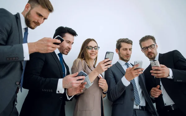 İş ekibi akıllı telefonlarının ekranlarına bakıyor. — Stok fotoğraf