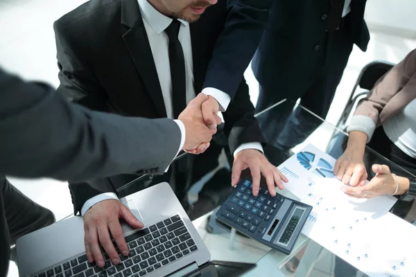 Une poignée de main à travers la table des partenaires financiers — Photo