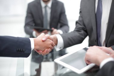 Ofiste iş arkadaşlarıyla tokalaşan adamlar..