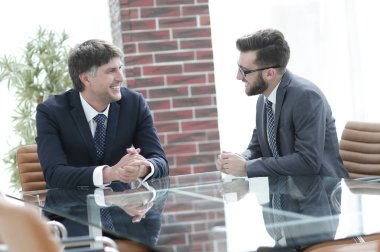 iki işadamı görevleri Office masada oturan tartışıyor.