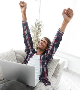 çok mutlu genç adam evde laptop ile çalışma.