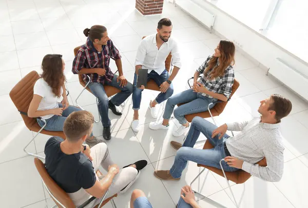 İş ekibi ofisin lobisinde bir toplantı düzenliyor.