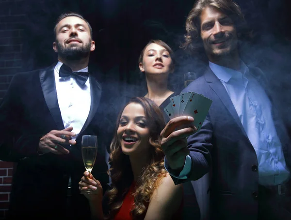 Four people toasting with champagne at roulette in casino — Stock Photo, Image