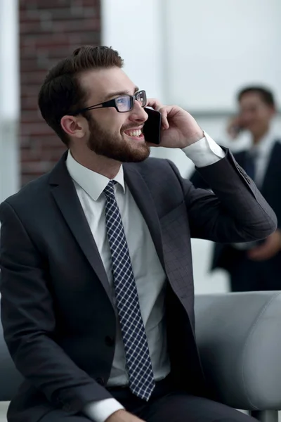 Empresário encantador falando ao telefone em um prédio moderno — Fotografia de Stock