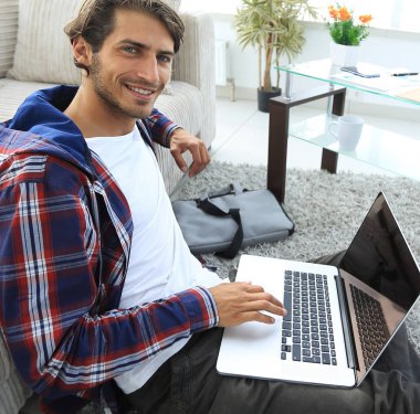 oturma odasında halı üzerinde oturan dizüstü bilgisayar ile iş adamı.