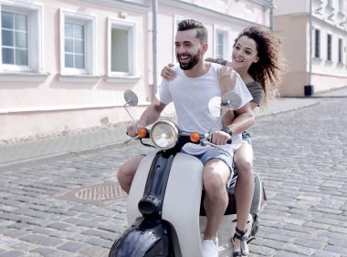 mutlu genç bir çift bir scooter üzerinde eğleniyor