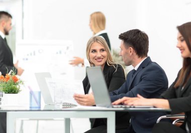 yeni bilgi tartışırken, açık belgili tanımlık laptop önünde duran iş takım