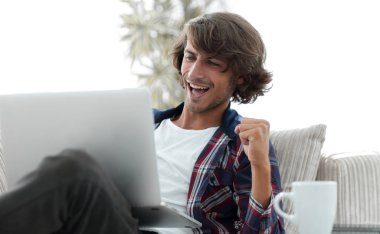 bir sehpa oturan bir dizüstü bilgisayar ile çok mutlu adam.