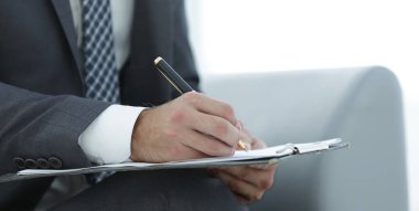 İşadamı bir sözleşme imzalar. Elinde kalem tutan.