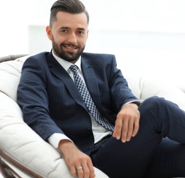 Kendine güvenen işadamı bir sandalyede oturuyor