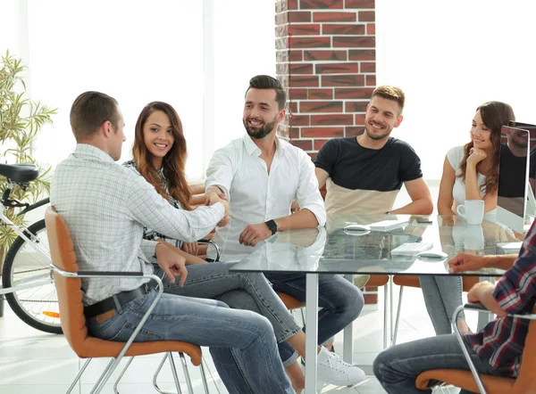 Handdruk van zakelijke partners zitten aan de tafel — Stockfoto