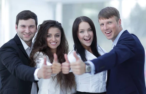 Equipe de negócios triunfante segurando polegares para cima — Fotografia de Stock