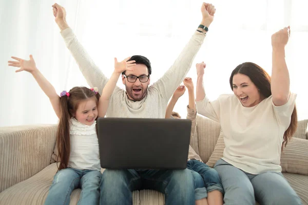 Счастливая семья смотрит свое любимое ТВ-шоу на ноутбуке — стоковое фото