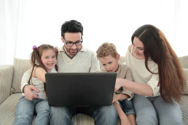 Familia moderna mirando a la pantalla del ordenador portátil . — Foto de Stock