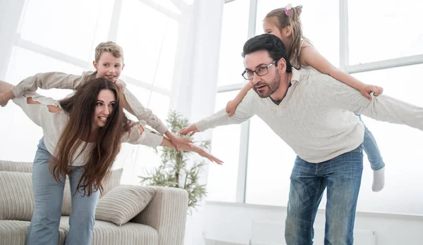 Cheerful parents play with their children in a bright living roo — Stock Photo, Image