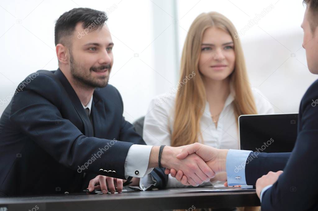 handshake financial partners sitting at the table
