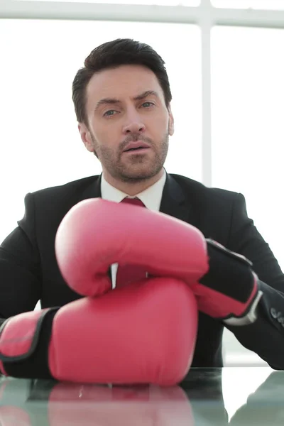 Zamknij up.businessman w czerwone rękawice bokserskie, siedząc przy biurku — Zdjęcie stockowe