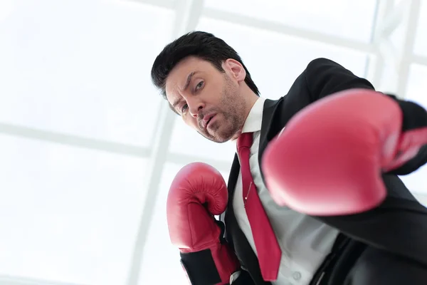 Close up.a serio hombre de negocios en guantes de boxeo rojo — Foto de Stock