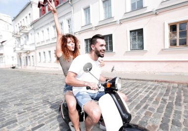 mutlu genç bir çift bir scooter üzerinde eğleniyor