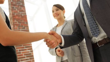 İş adamları geniş pencereli odaya karşı el sıkışıyor