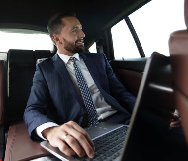 Arabanın içinde otururken kendine güvenen iş adamı