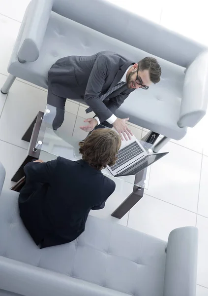 Dois homens de negócios discutindo tarefas sentados à mesa do escritório . — Fotografia de Stock