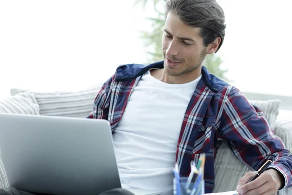 Selbstbewusster Typ, der zu Hause mit Laptop arbeitet. — Stockfoto