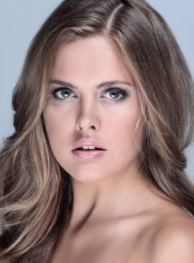 Genç mutlu gülümseyen düşünme kadın, gri backgr portresi