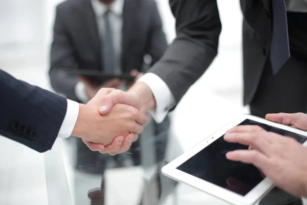 Mannen schudden handen met een glimlach op kantoor met hun collega 's. — Stockfoto