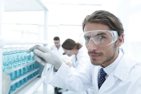 Людина в окулярах для перевірки рідини in vitro . — стокове фото