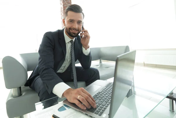 Foreground businessman talking on a smartphone — Stock Photo, Image