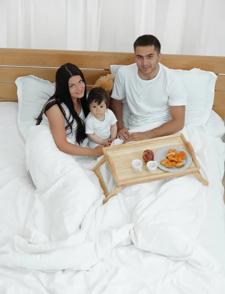 Matka, otec, dítě na lůžku v pokoji — Stock fotografie