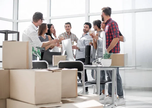 Бизнес-команда празднует переезд стоя в офисе — стоковое фото