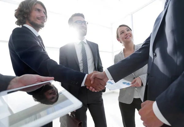 Anställda ser på de handshake affärspartnerna — Stockfoto