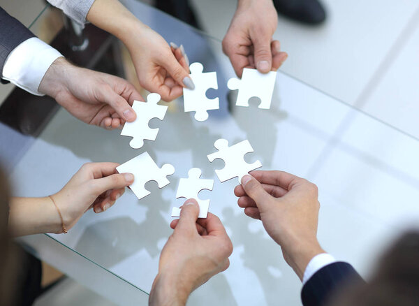 Business people holding jigsaw puzzle.