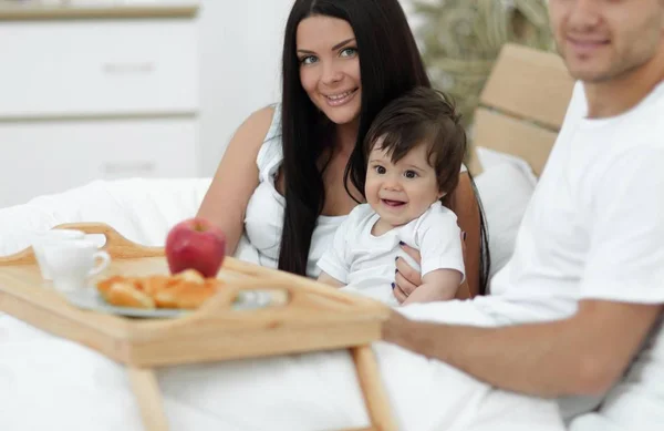 Família tomando café da manhã na cama em casa — Fotografia de Stock