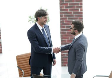 İki işadamı ofiste el sıkışıyor.