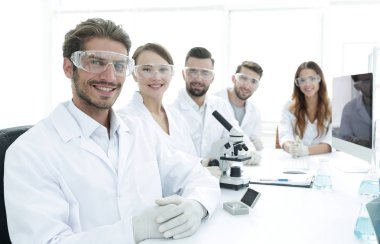 Erkek bilim adamı ve laboratuarda takım.