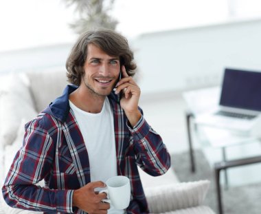 güzel bir fincan adamla bir dizüstü bilgisayar önünde oturur.