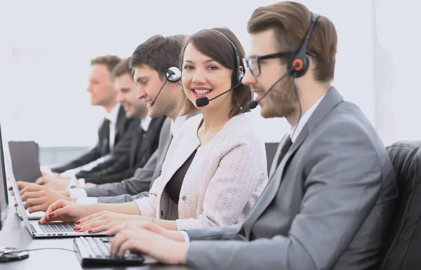 Call center operador com colegas sentados no local de trabalho — Fotografia de Stock