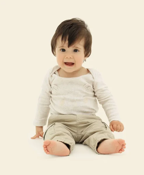 Engraçado bebê sentado no chão, isolado sobre branco — Fotografia de Stock