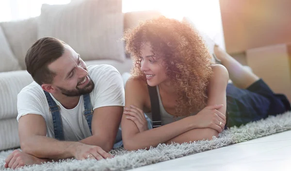 Pareja feliz yace en el suelo en un nuevo apartamento —  Fotos de Stock