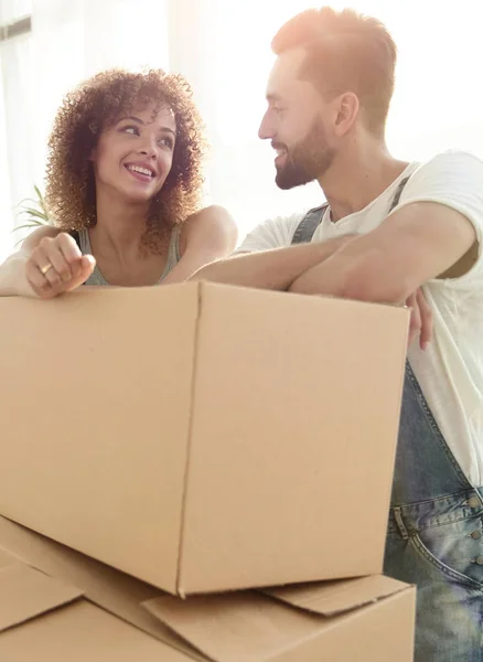 Joyeux couple debout près des boîtes dans leur nouvel appartement . — Photo