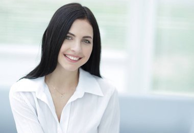 bulanık bir arka plan üzerinde bir masada oturan başarılı genç kadın.