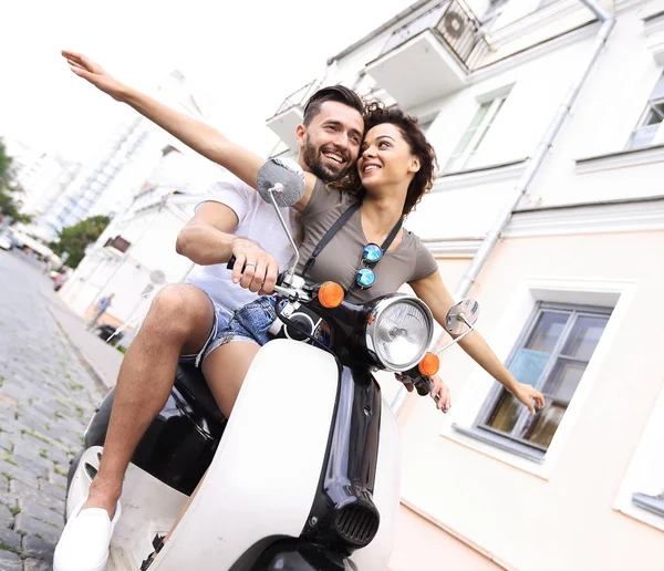 Mooie jonge paar lacht tijdens het rijden een scooter — Stockfoto