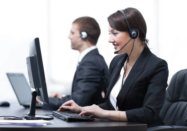 Agente de servicio al cliente femenino con auriculares trabajando en un centro de llamadas —  Fotos de Stock