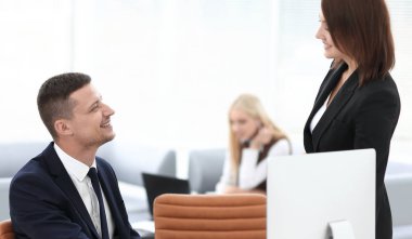 ofiste bir masanın arkasında oturan çalışanlar