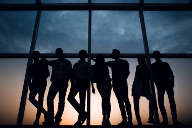 yaratıcı iş takım ayakta ofis pencere yakınındaki.