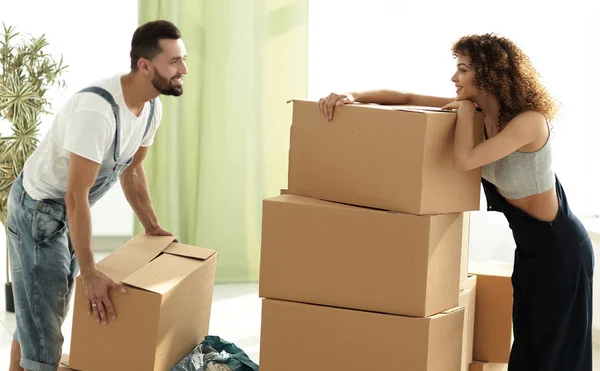 Jovem casal desempacotar caixas em uma nova casa — Fotografia de Stock